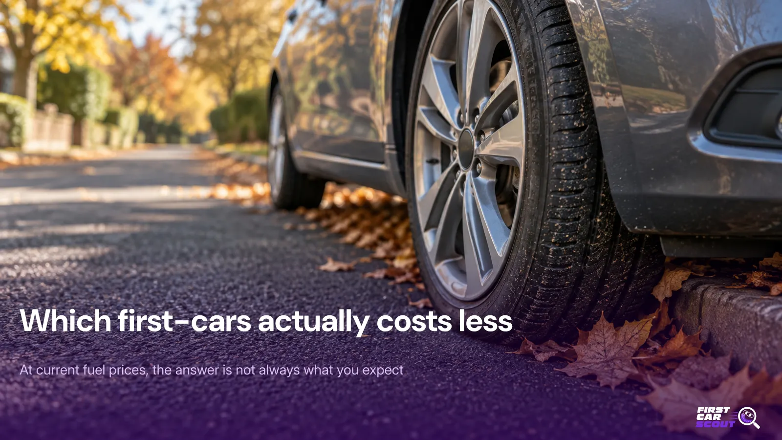 Close-up of a grey hatchback's front wheel parked on a UK street lined with autumn leaves, with the headline Which first-cars actually costs less.